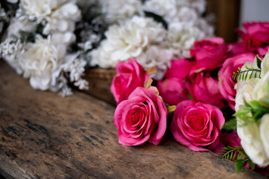 Pink rose floral arrangement white flower pink rose floral arrangement rustic wooden table with soft focus white flowers and green foliage, creating romantic decorative scene for wedding or event