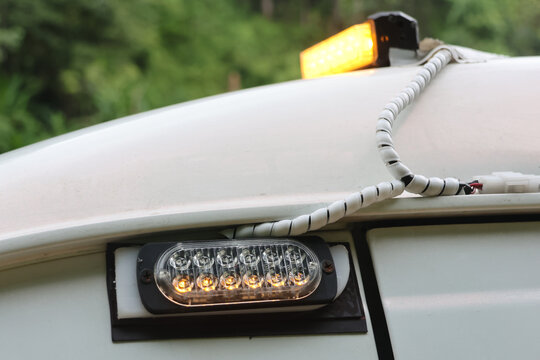 Emergency vehicle warning light and side signal lamp on white utility truck outdoors