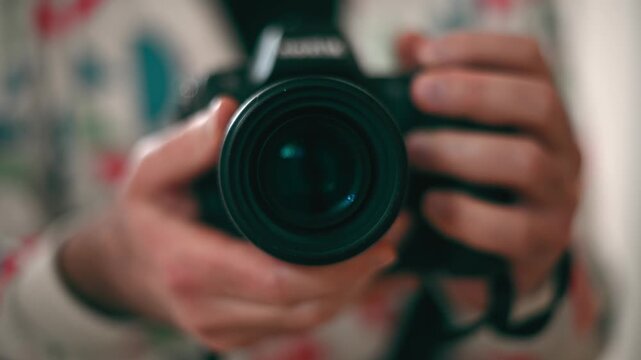 Close up of hands holding a professional DSLR camera, ready to take a photo.