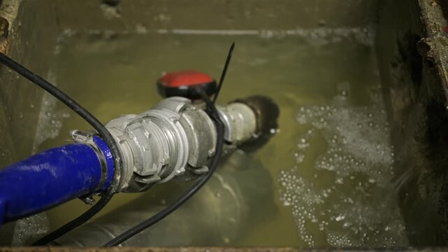 Industrial water pump system operating in a concrete containment tank to process fluid and prevent flooding in technical facilities.