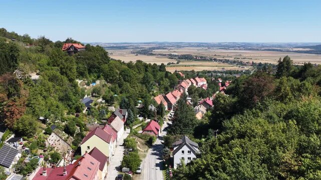 Aerial drone view of Srebrna Gora village in Lower Silesia, Poland, with historic Srebrna Gora Fortress, surrounding mountains and green landscape on a sunny summer day