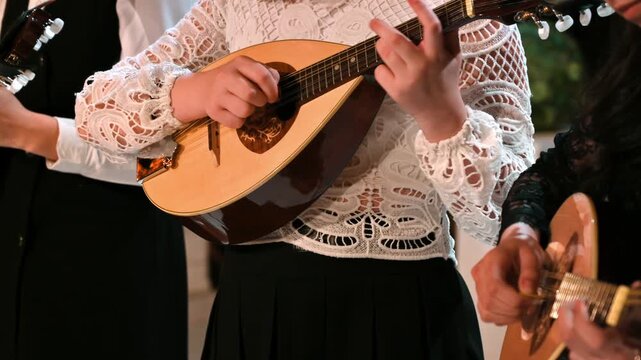 Group of female musicians playing traditional mandolin instruments during acoustic performance.