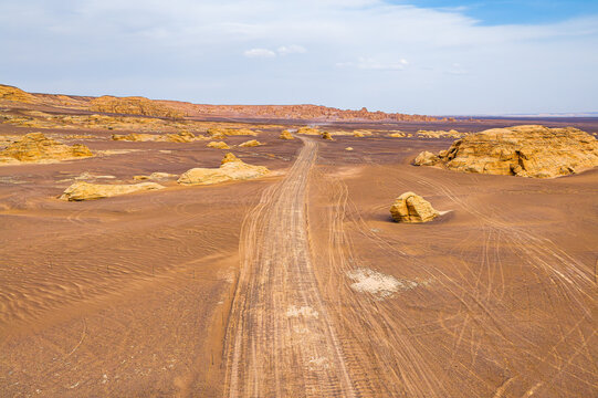 Dirt road cutting through yardang landforms in Dahaidao, Xinjiang, China.