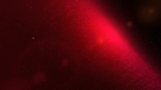Abstract red dust particles floating in dark space background with glowing light effects