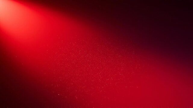 Red spotlight shining on particles in the air creating dramatic light effect with dark background