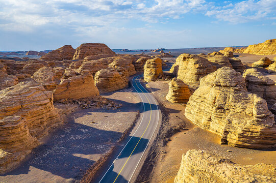 Winding road through Dahaidao yardang landform in desert, Xinjiang, China.