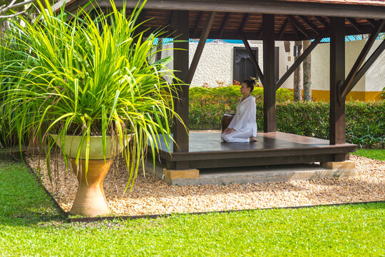 Woman in gazebo practicing yoga in Thailand in Asia