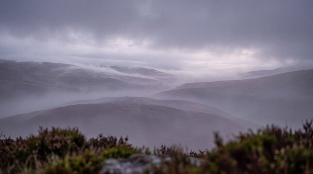 Misty mountain landscape with rolling hills and low clouds in the peak district, england