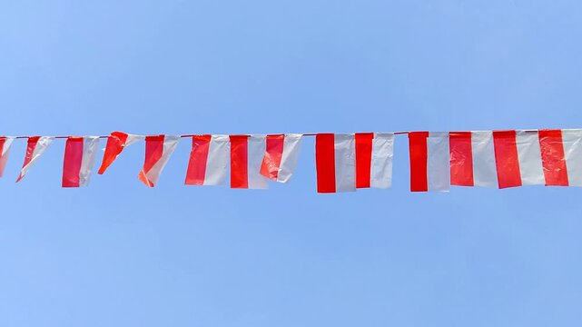 Indonesia independence day red and white bunting flag garland hanging against clear blue sky outdoor celebration