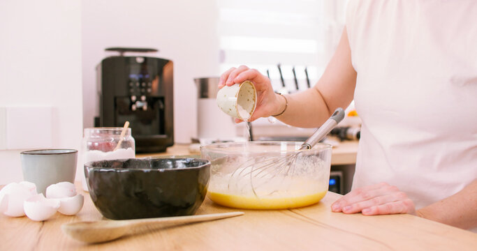Dessert recipe. Home cooking. Chef female hand adding measured baking powder portion to bowl preparing whisk dough on kitchen counter.