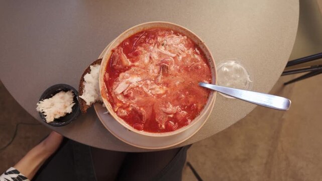 Traditional Ukrainian borscht served with rye bread, sour cream, salo on table
