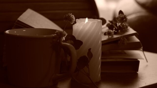 Candlelight in the dark, flowers and reading book. Cozy evening at home.  Burning candle
