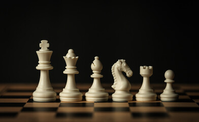 line-up of various white chess pieces on a wooden board, black background © geargodz