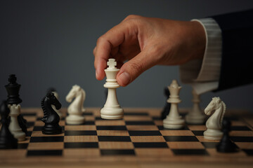 hand placing white chess king on wooden board, business strategy concept © geargodz