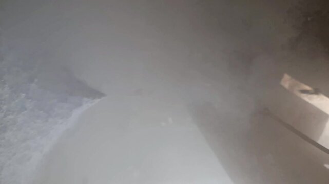 Cryogenic liquid nitrogen leak and dry ice sublimation producing dense cold vapor under heavy industrial machinery.