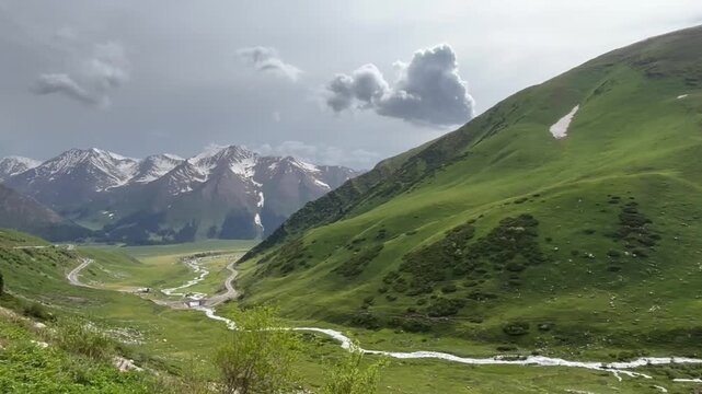 The Duku Highway (G217) winds dramatically through a vibrant, mountainous valley in Xinjiang, showcasing one of China&rsquo;s most scenic routes.