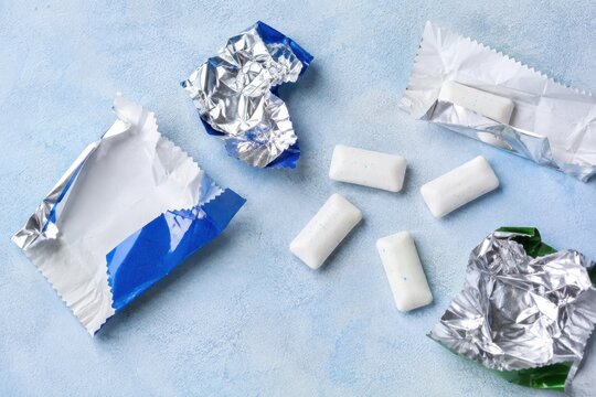 Chewing gum pieces with foil wrapper on a textured background