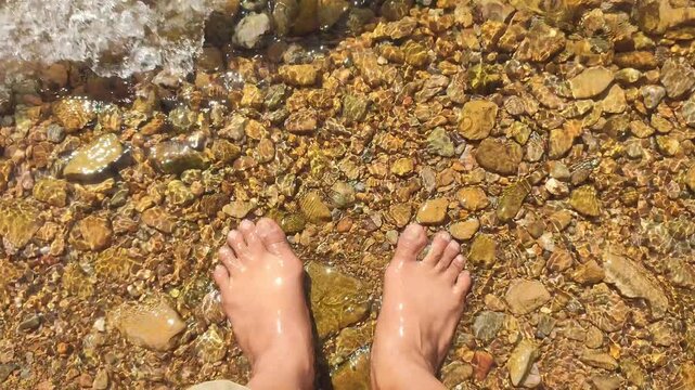 Feet in Clear Shallow Water over Pebble Lake Bed at Lake Toba