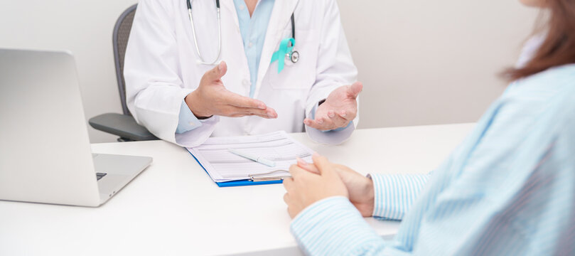 Doctor and patient having a medical consultation for Teal ribbon concept of September Ovarian Cancer Awareness month, PCOS, January Cervical Cancer, April Sexual Assault, June PSTD
