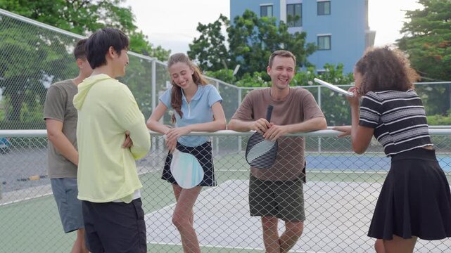 Group of diverse pickleball players standing together on outdoor court. 