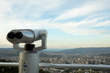 City skyline viewed through binoculars from elevated viewpoint