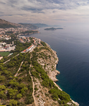 Aerial view of the Adriatic coast in Dubrovnik. Dalmatian cliff coastline with forest and mountains. Bays and beaches in Dubrovnik, drone photo. Summer in Croatia.