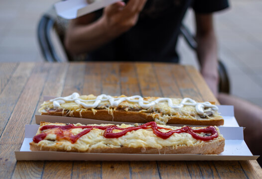 Two Polish traditional delicious  Zapiekanka sandwiches on a table outdoors.