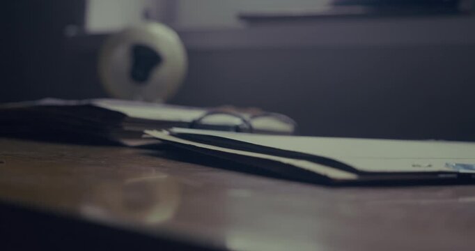 Close-up of a telephone engineer picking up a vintage rotary buttset from an office desk, illustrating telecommunications testing and analogue communication equipment.