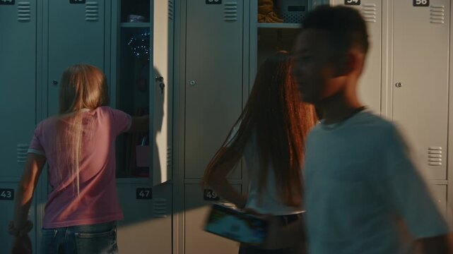 Two Female Middle School Students Share Warm, Affectionate Hug by Open Lockers in Sunlit Educational Hallway. Lifestyle Concept of Childhood Friendship, Peer Support, Welcoming School Environment.