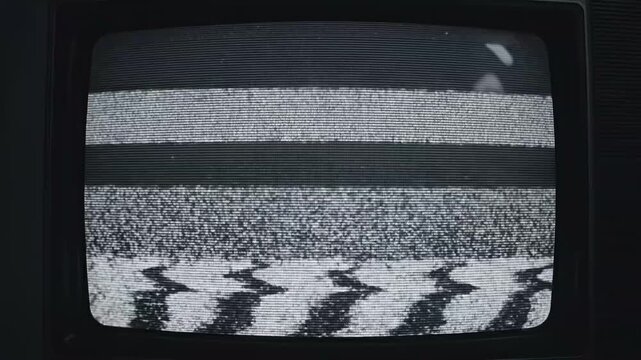 A full-frame close-up of an old analog CRT television display experiencing a slowly deteriorating broadcast signal
