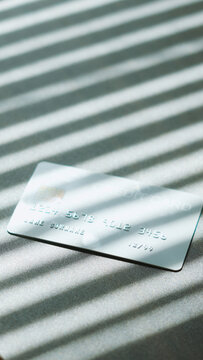 E-commerce checkout, Silver credit card with natural sunlight shadow effect for payment concept.