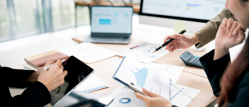 Close Up Business People Pointing Pen at Financial Reports and Using Tablet in Office