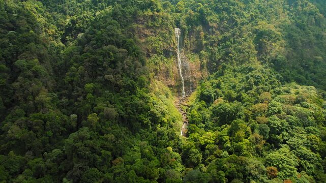 Aerial view of a tall Costa Rica waterfall surrounded by dense green jungle