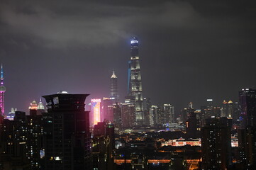 Fototapeta premium Night time view of the Shanghai city skyline - a panorama photo of the modern architecture and dense urban environment in the evening