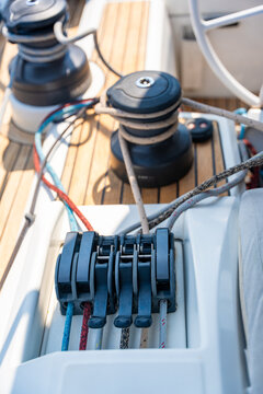 Close up of rope clutches, winches and running rigging on cockpit deck of a modern sailing yacht. Marine equipment, sail control, navigation, seamanship, nautical technology, boating and yachting 