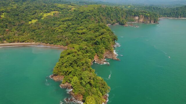 Lush jungle hills meet turquoise ocean waters on rugged coastline of Costa Rica