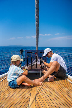 Father and daughter learning yacht maintenance together during a family sailing adventure. Building practical sailing skills, teamwork, confidence and responsibility through shared experience.