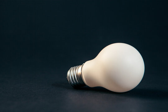 Incandescent light bulb on black background with copy space for text