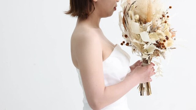 恥ずかしそうにブーケで顔を隠す花嫁