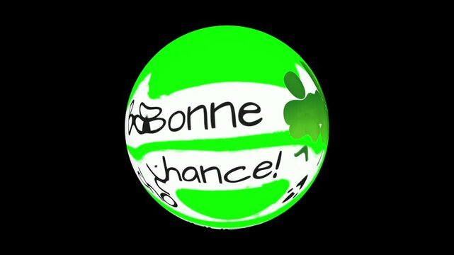 Green glass orb showing hand drawn French text saying Bonne Chance with lucky four leaf clover illustrations, displayed in the center of a pitch black background for designs.