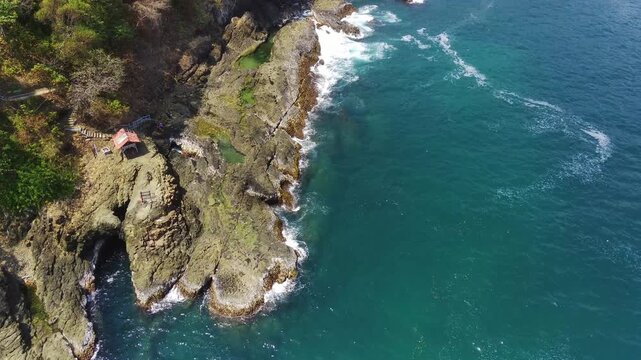 Drone Flying Over White Sand Beach and Clear Blue Ocean rocky mountain