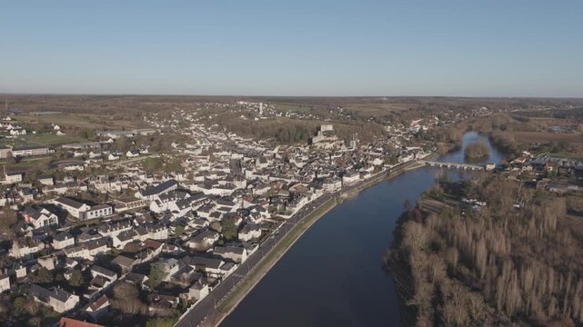 An aerial view shows a riverside town nestled along a wide bend in the Loire River in France.
