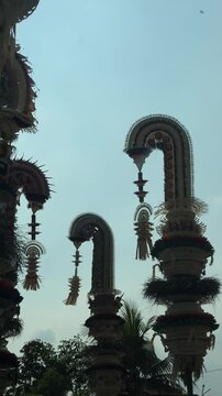 Traditional Balinese Penjor decoration against the blue sky during Galungan and Kuningan celebrations, symbolizing prosperity, gratitude, and spiritual devotion in Balinese Hindu culture.