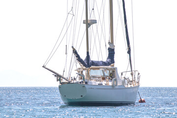 Obraz premium Sailboat lay at anchor offshore. Luxury yacht concept. Boat on sea or ocean. Ship or marine vessel..