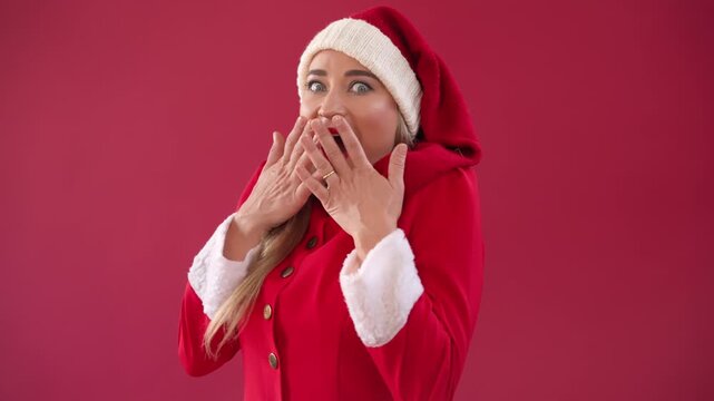 Joyful Christmas celebration with a woman in a Santa costume showing festive emotions in a red background