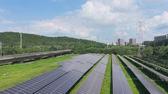 Aerial view advancing over solar panels toward a city skyline