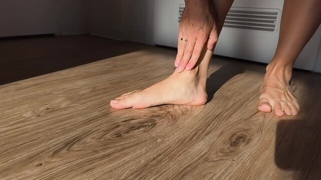 Bare feet showing low foot arch on a wooden floor