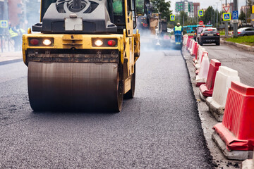 Naklejka premium Road Roller Paving New Asphalt on a City Street