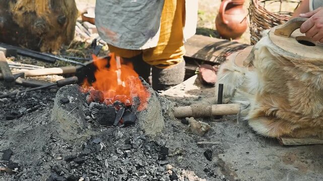 In an outdoor setting, a person is using a prepared bundle to create fire from natural materials. This process showcases traditional techniques that emphasize skill and patience