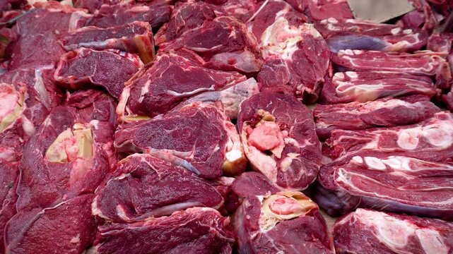
Meat counter. Butcher shop. Fresh meat for sale. Large pieces of fresh meat lie on the counter. Slowmotion 4k video shot.